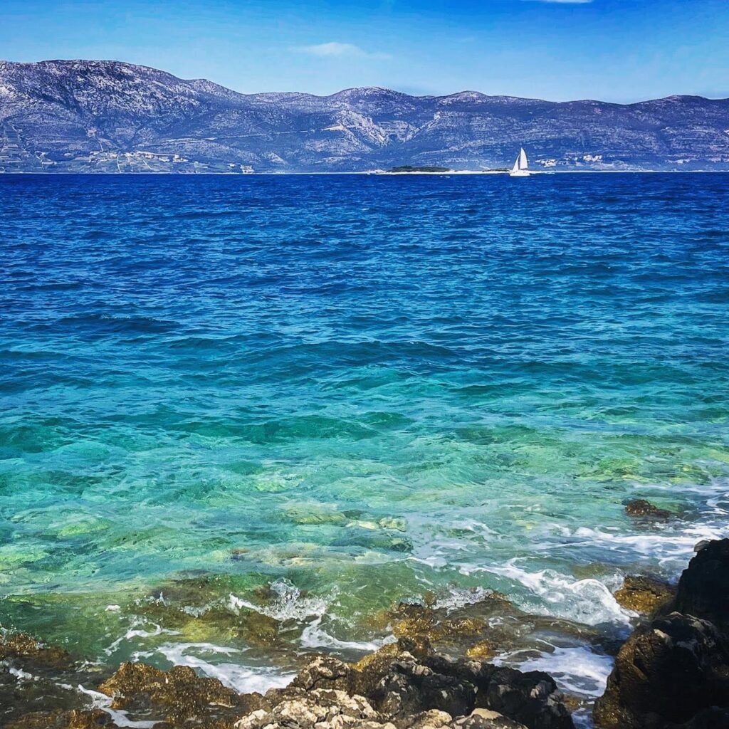 The Adriatic with a sailboat and mountain in the distance