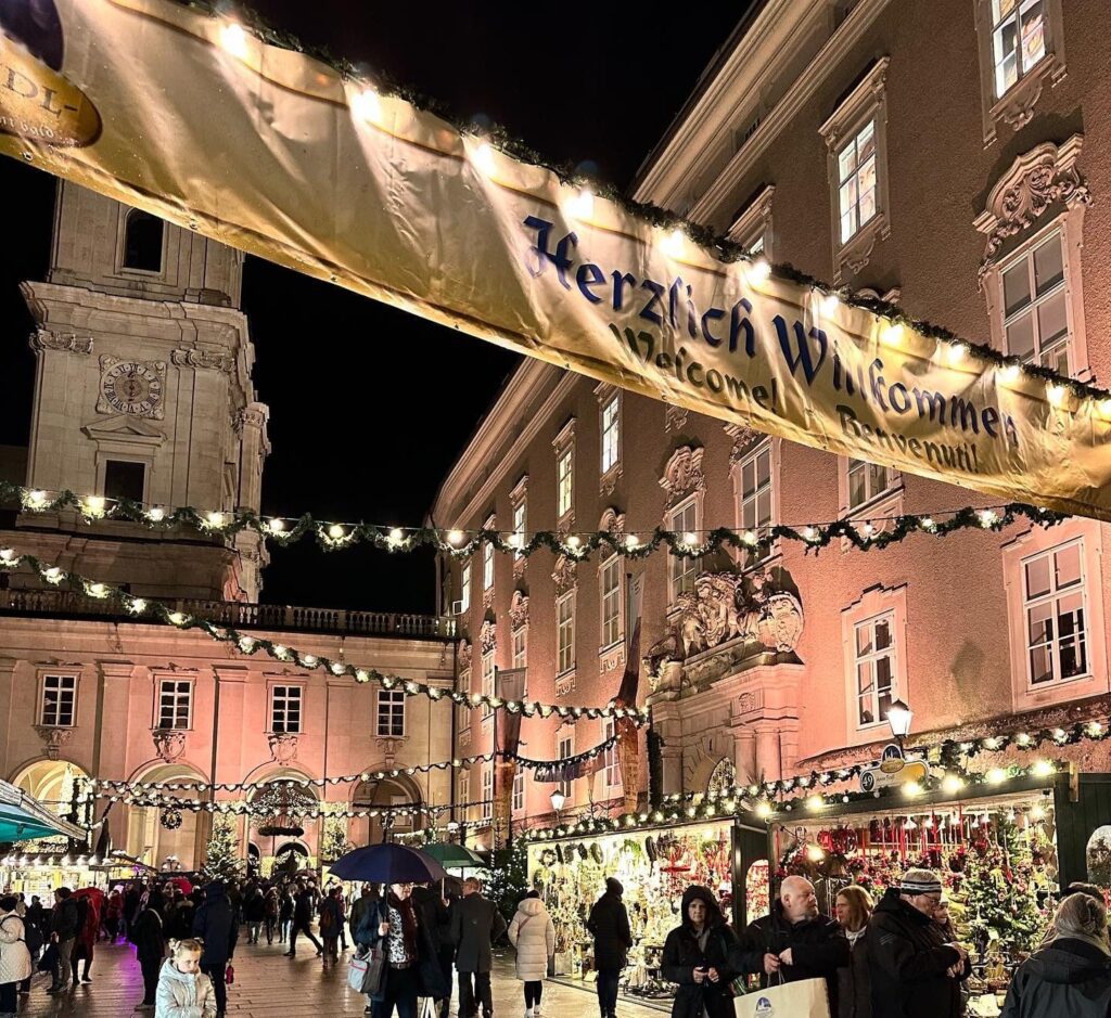 Austrian Christmas Market at night - Salzburg with people shopping at booths