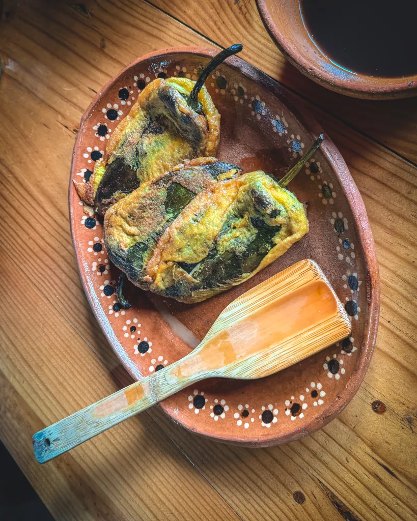 Stuffed green peppers and a serving spoon on a plate at Xotolar Ranch near San Miguel de Allende
