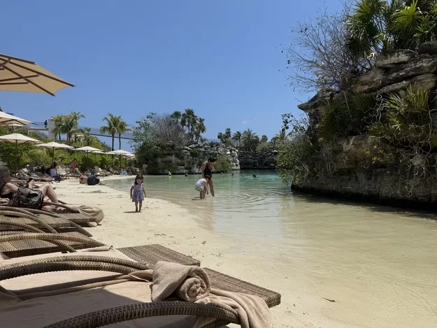 Hotel Xcaret Review - "beach" area by the water with comfortable chairs 