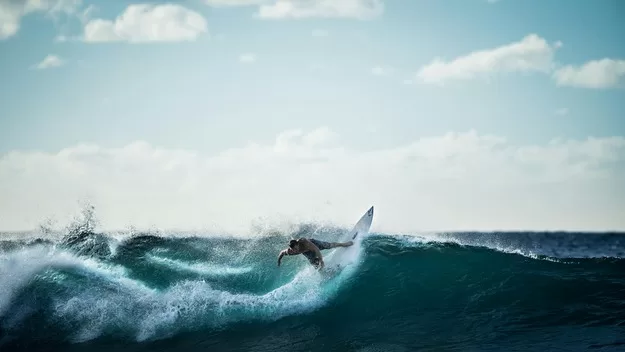 A male surfer catching a wave in the ocean Photo by Life of Pix