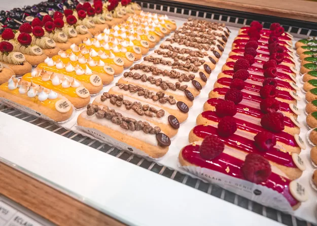 Rows of colorful eclairs at a stop on a food tour in Paris