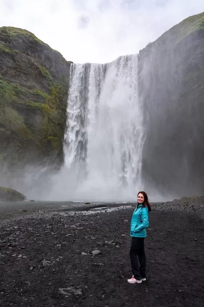 Lindsey from Adventurous Tastes in front of dramatic waterfall