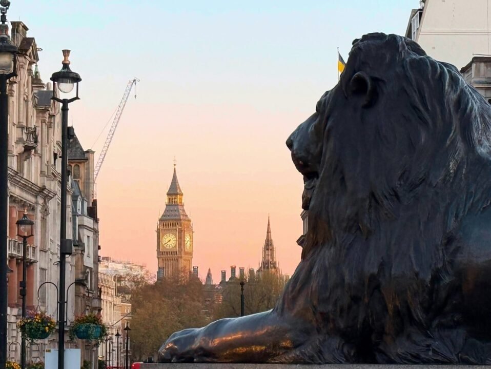 Lion statue in foreground and big ben in background in London