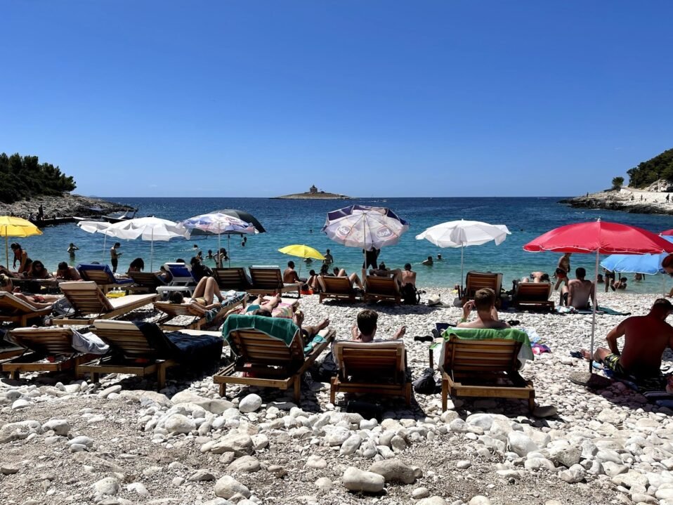 sun loungers and umbrellas on rocky Croatian beach