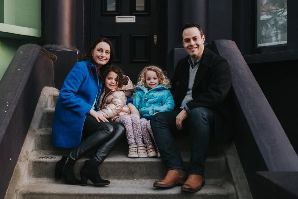 Family on staircase in Notting Hill, London, in front of brightly colored home