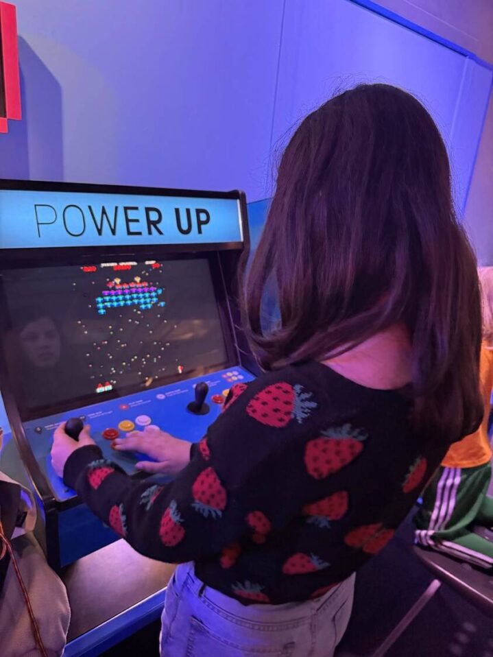girl playing video game at Power Up exhibit